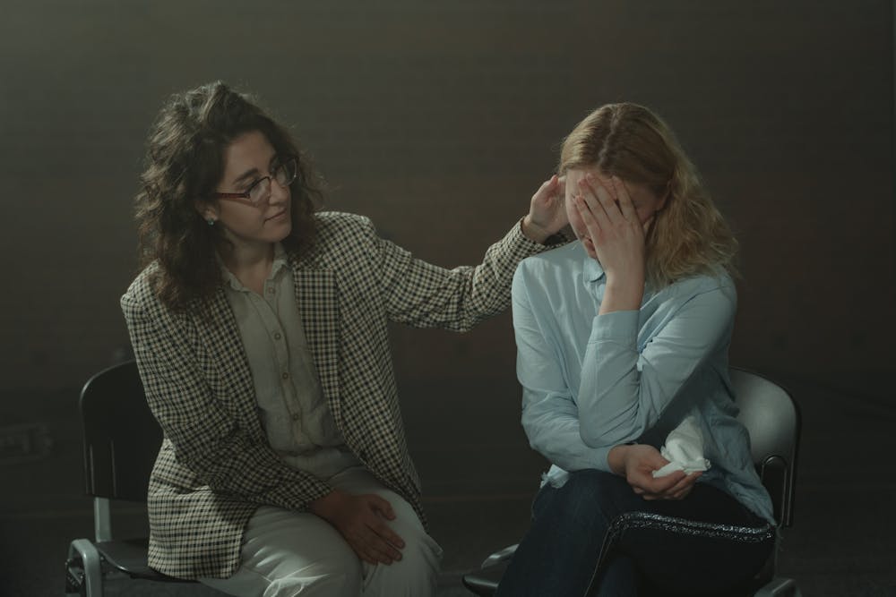 Woman offering another woman support during a support group meeting.