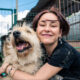 A woman holding a long-haired dog at the shelter and wondering, do you have to pay to adopt a dog?