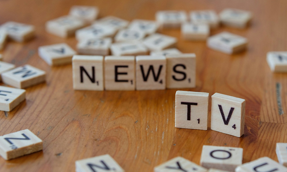 Scrabble blocks spelling the words “News” and “TV”.